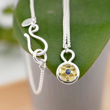 Load image into Gallery viewer, The Beacon of Hope necklace depicts a single glistening forget-me-not flower, symbolizing light, hope, and enduring love. This necklace is handcrafted using your choice of tarnish resistant sterling silver and/or solid 18K yellow gold, 18&quot; argentium silver wheat chain &amp; a Ceylon blue sapphire. Chloe Leigh Designs: Handcrafted Fine Jewelry