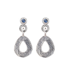 Load image into Gallery viewer, These hand-textured silver dangle post earrings features 3mm ocean blue Montana sapphires. These teardrop dangles have a wider base to make a statement. 