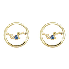 Load image into Gallery viewer, These stud earrings are handcrafted with solid 18K yellow gold, &amp; a single 3mm Ceylon blue sapphire embraced in the middle of an abstract array of gold granulation. Against a white background. 