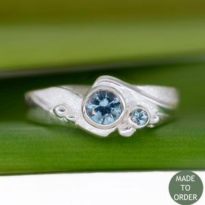 This ring, Rising Tide, embodies the motion and the balance of the sea. The ocean-blue Montana Sapphires are encircled by wave formations sculpted in silver. Around the gemstone, the metal is hand-textured creating a sparkling sand-like finish along with sea foam bubbles that dance across the wave. The band is finished with a high polish.